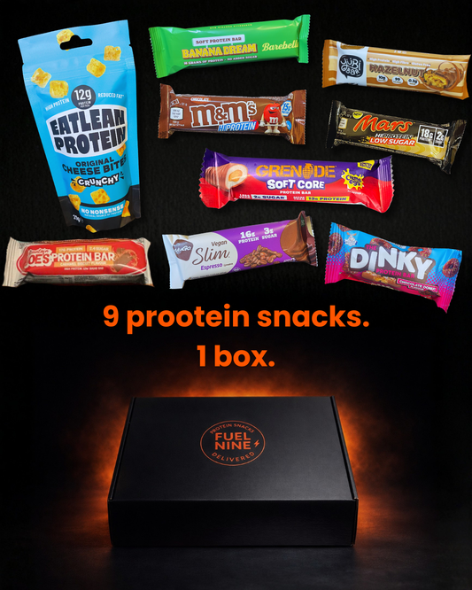 Assorted protein bars from different brands displayed in front of a black box with 'FuelNine' branding.